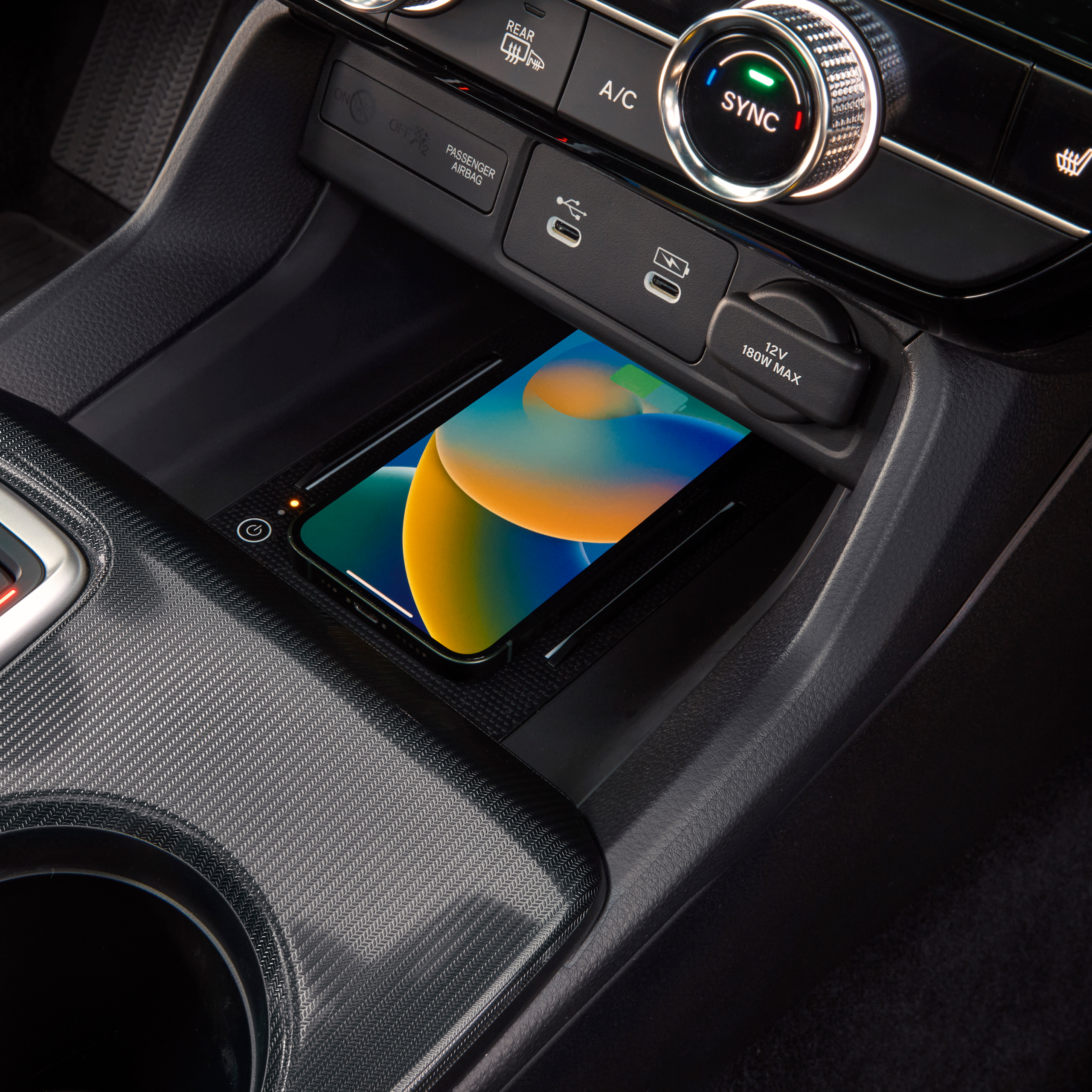 Nærbillede af en telefon, der oplades trådløst inde i Civic Hybrid.